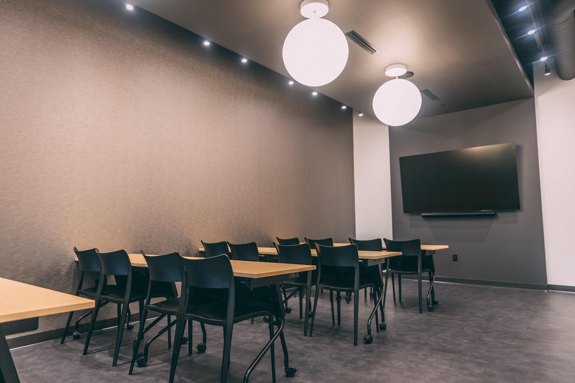 Essere Caffè event space with seating and display screen
